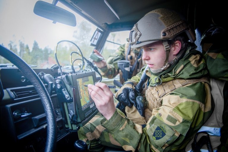 Soldat i bil skriver på en skjerm.