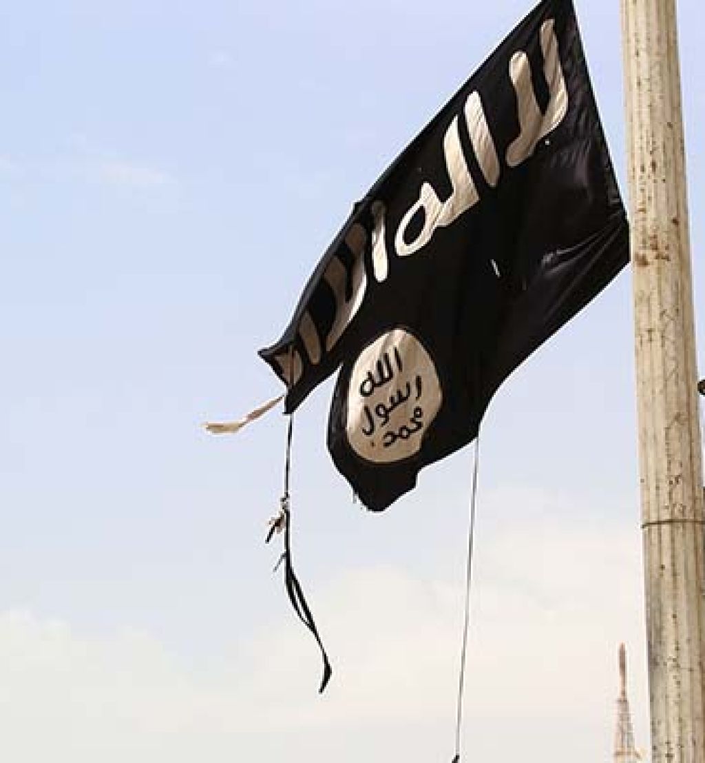 (FILES) In this file photo taken on April 30, 2017 A member of the US-backed Syrian Democratic Forces (SDF) removes an Islamic State group flag in the town of Tabqa, about 55 kilometres (35 miles) west of Raqa city as they advance in their battle for the group's de facto capital.The Islamic State jihadist group has executed one of dozens of Druze hostages abducted from Syria's southern province of Sweida last month, a Syrian news outlet and a monitor said on August 5. IS killed the 19-year-old male student on August 2 after kidnapping more than 30 people, mostly women and children, from a village in Sweida during a deadly rampage on July 25, the head of the Sweida24 news website Nour Radwan said. / AFP PHOTO / DELIL SOULEIMAN