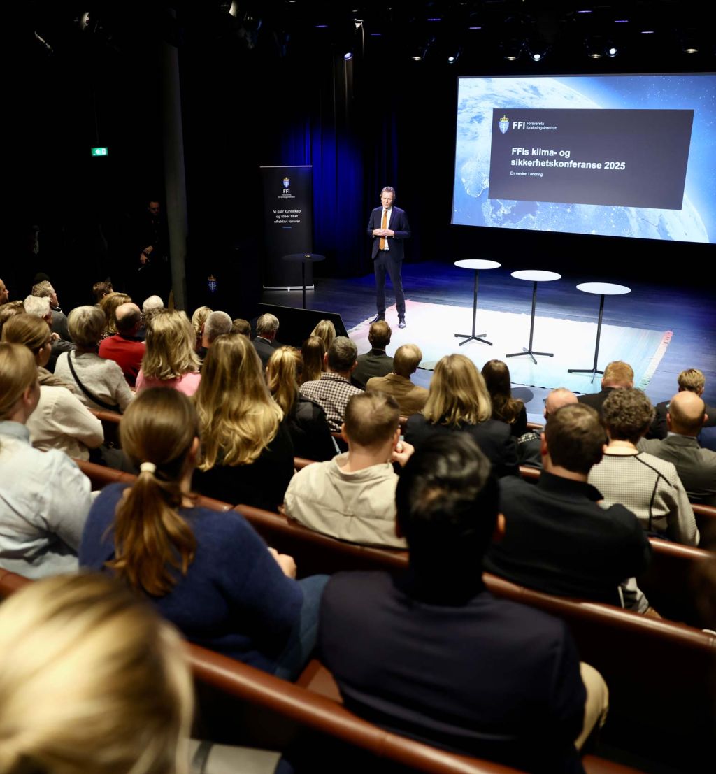 Erik Wold på scenen foran et fullsatt Deichmansal.