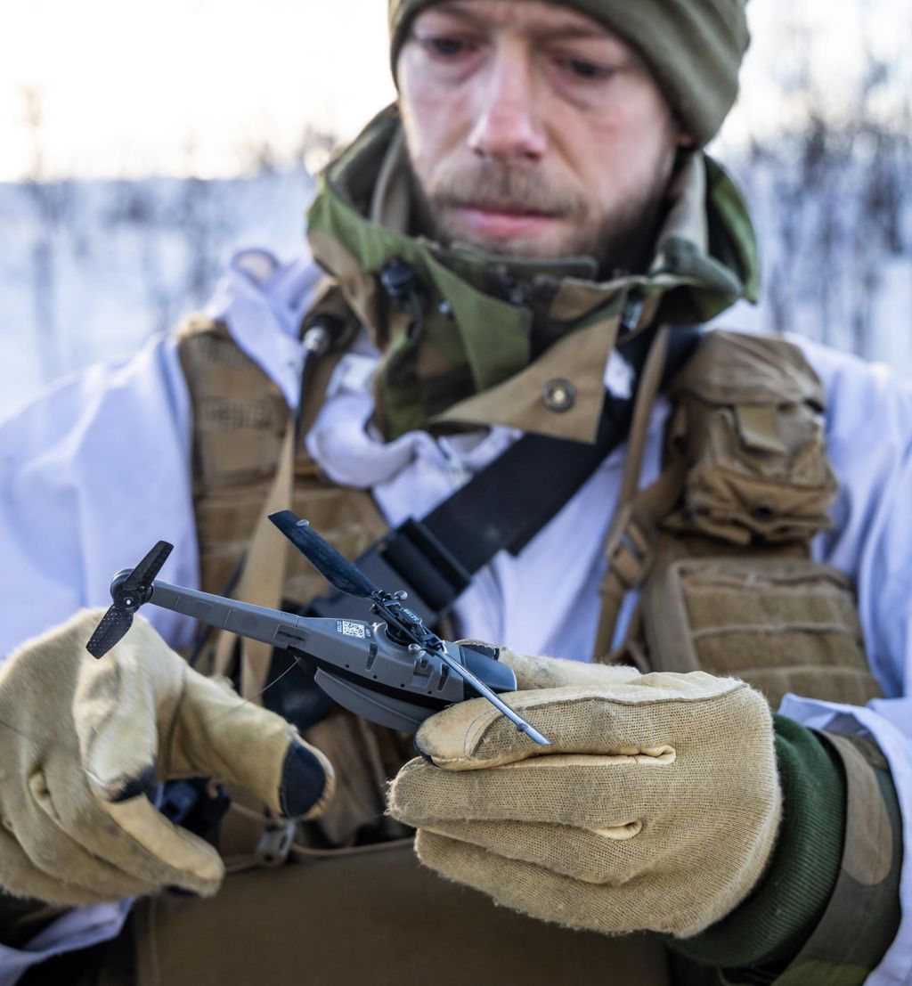 Soldat i vinteruniform som holder en drone, en Black Hornet 3.