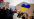 kvinne holder opp en plakat under en demonstrasjon med et hjerte med de ukrainske fargene