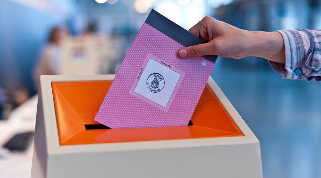 Person legger en stemmeseddel i stemmeurne. Illustrasjonsfoto. Stortingsvalget 2021.