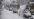 Soldater på snøscooter og cv-90 panservogner i kolonne i tett snøvær.