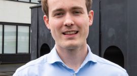 Benjamin står i fin blå skjorte og ser inn i kamera