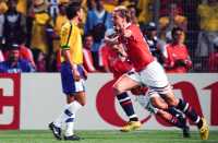 Fotballspiller Kjetil Rekdal i norsk landslagsdrakt (rød og hvit) jubler etter å ha skåret mot Brasil.