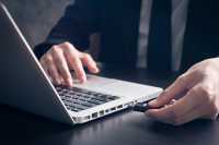 nærbilde av laptop og en minnepinne