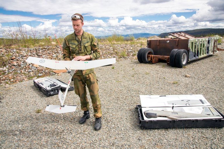 Soldat holder drone som ligner glidefly