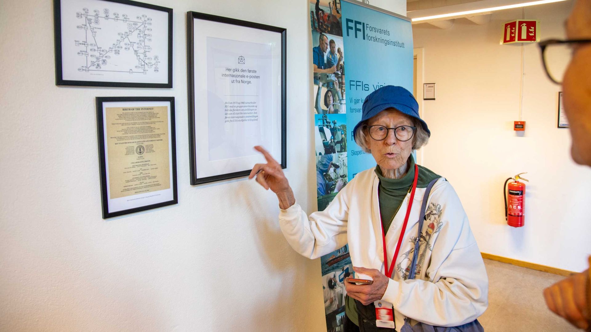 Bente Lundh studerer plakaten som forteller at den første eposten i Norge ble sendt fra dette lokalet.