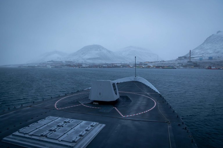 KNM Thor Heyerdahl seiler inn mot Longyearbyen i et blågrått vær.