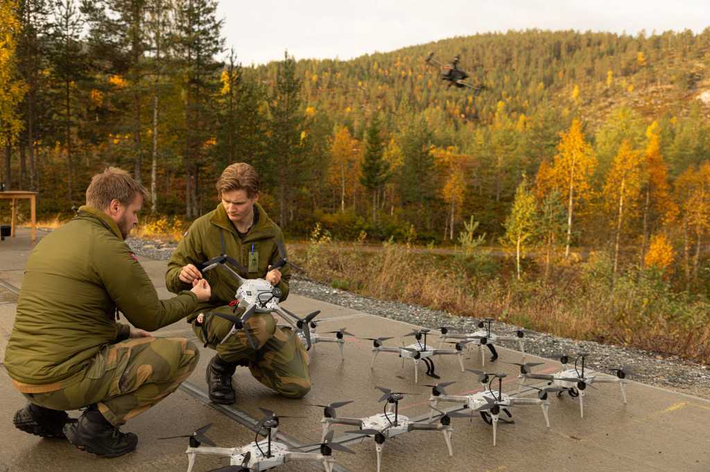 To soldater med en rekke droner på en platting.