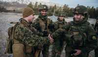 Gardister fra Hans Majestet Kongens Garde snakker med korporal King fra US Marine Corps under NATO-øvelsen Trident Juncture 2018 i Oppdal