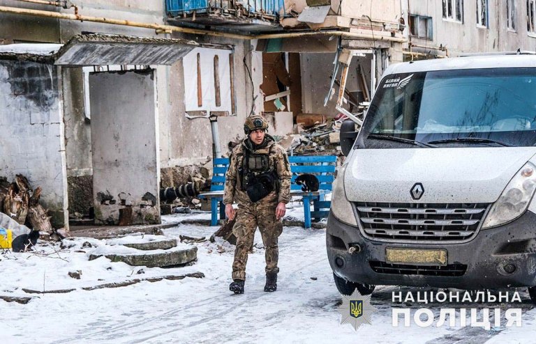 En soldat ved siden av en hvit varebil.