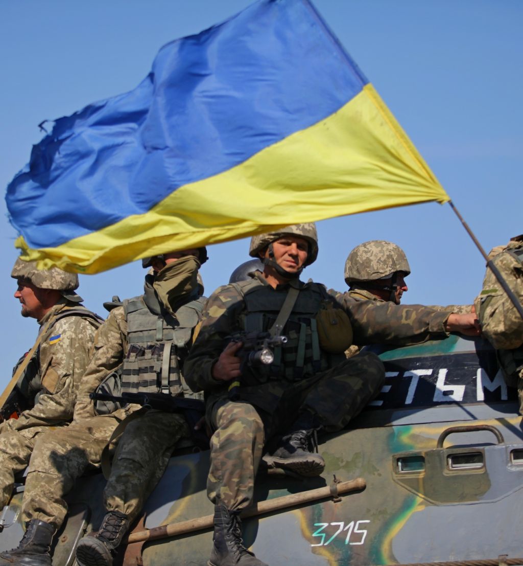 Soldater sitter på tanks med ukrainsk flagg. Foto