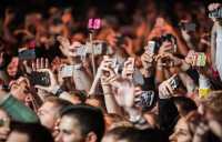 Unge mennesker med smarttelefoner på konsert