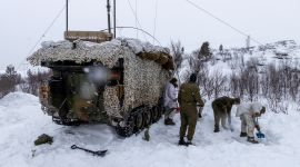 Fire soldater graver plass til teldt ved siden av en kommandovogn. Snø og vidde. 