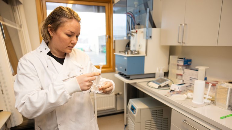 kvinnelig forsker på lab holder på med noen jordprøver