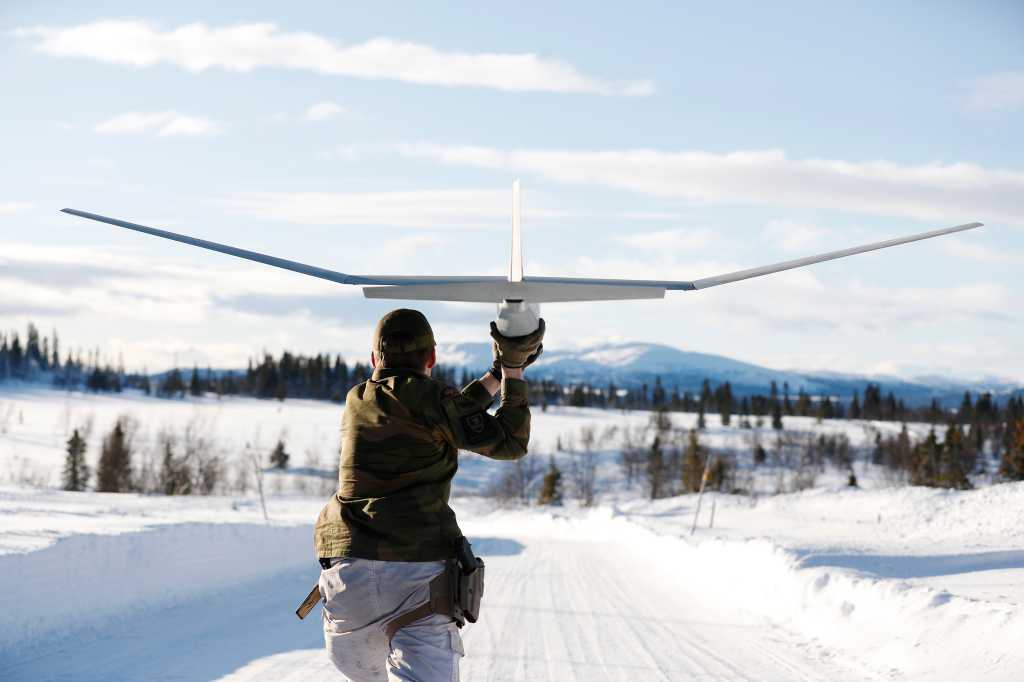 Soldat sender drone av gårde i vinterlandskap