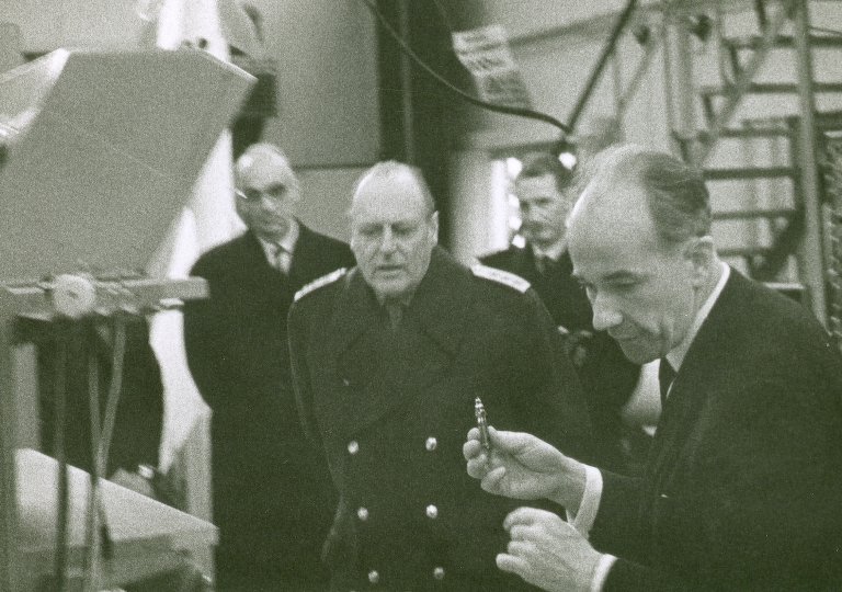 Årstallet er 1969: Forskningssjef Karl Holberg demonstrerer Penguin-søkerens infrarøde detektor for kong Olav. I bakgrunnen til venstre står FFI-direktør Finn Lied.