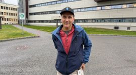 Portrett av forsker utendørs med FFI-bygniger i bakgrunnen.