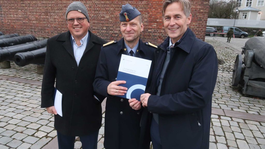 Tre menn viser frem Forsvarets dronestrategi.