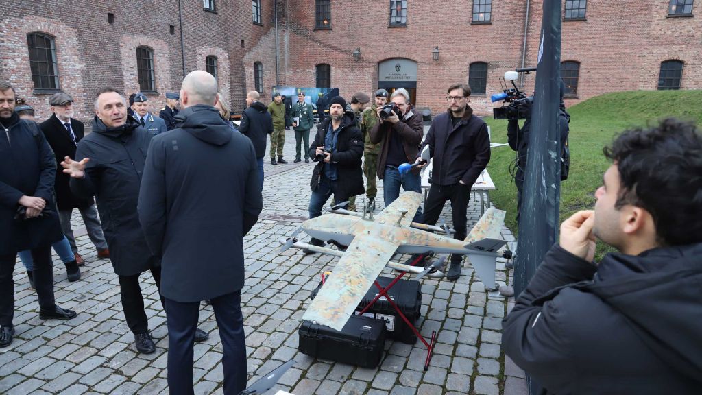 Statsråd Sandvik får en orientering utendørs med mange personer som tilskuere.