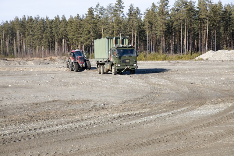En selvkjørende traktor følgeer etter en lastebil. Fra et autonomieksperiment på Eggemoen mars 2021.
