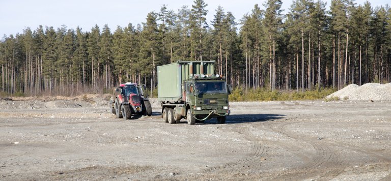 En selvkjørende traktor følgeer etter en lastebil. Fra et autonomieksperiment på Eggemoen mars 2021.