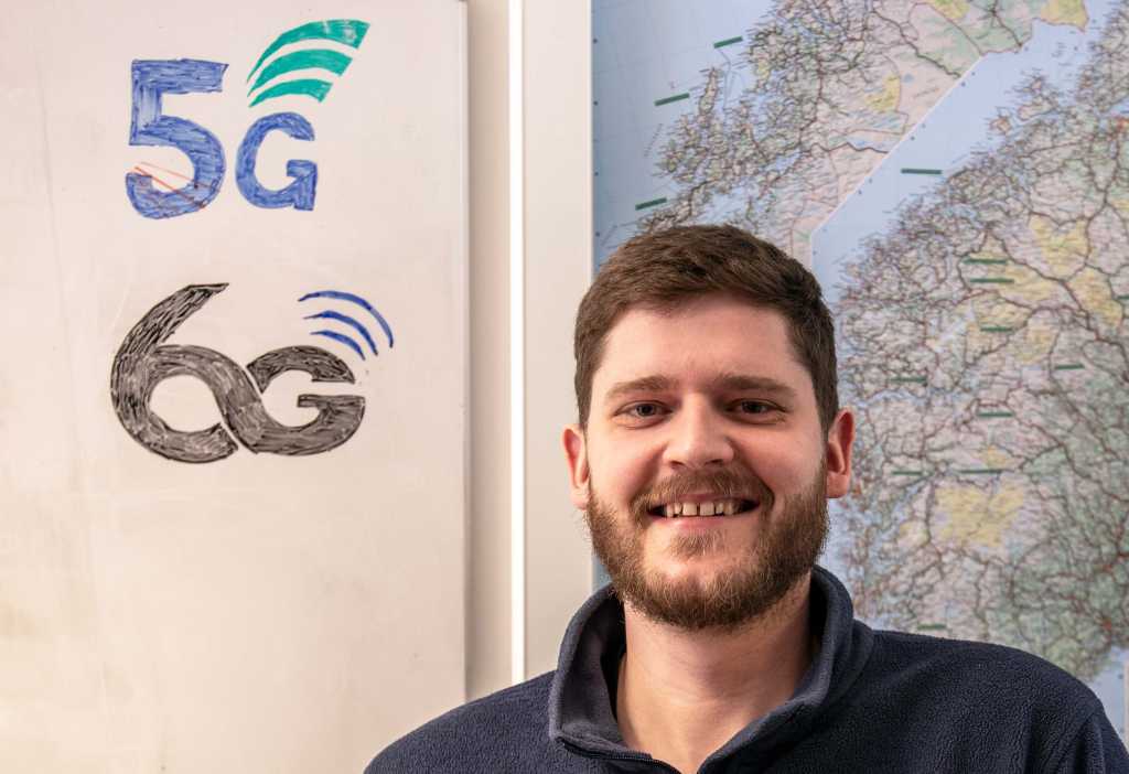 En forsker foran et norgeskart og logoene til 5G og 6G på venstre side.