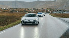 Tre biler kjører bortover en vei på Andøy. Fjell og nordnorsk natur i bakgrunnen.