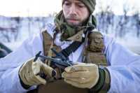 Soldat i vinteruniform som holder en drone, en Black Hornet 3.
