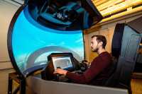 Mann som sitter i simulator. Foto
