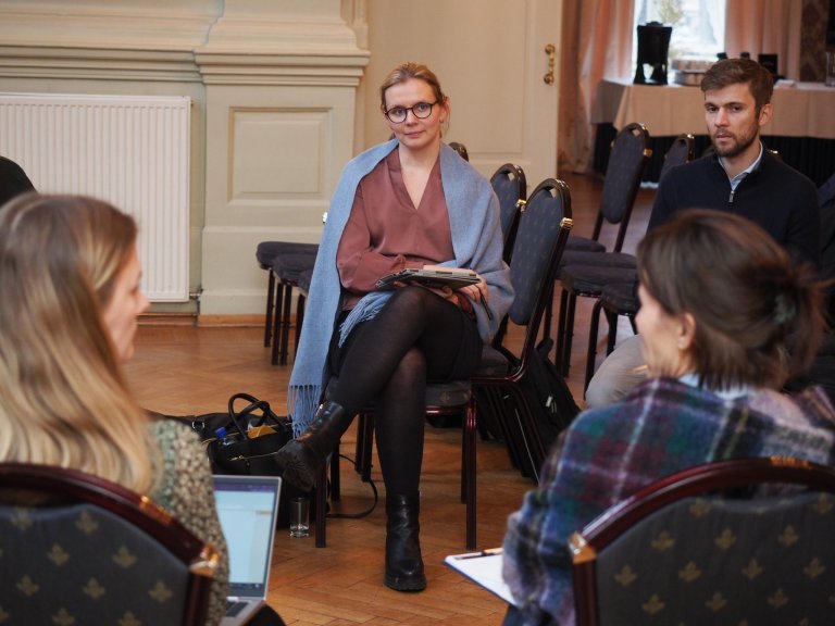 Gruppe mennesker som sitter i ring og diskuterer