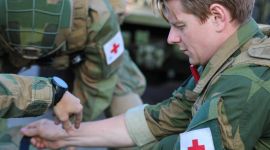 Soldater fra Forsvarets sanitet sitter på huk