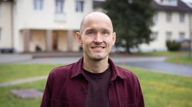 Nærbilde av Olger Breivik i burgunder skjorte.