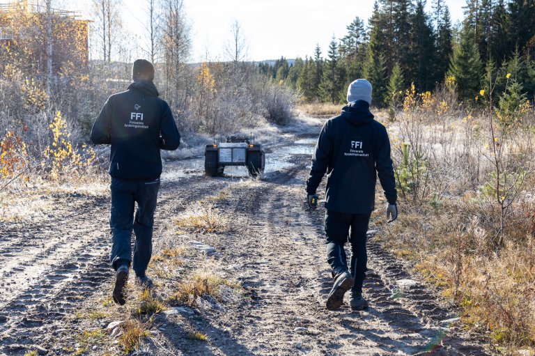 To forskere kjøer et ubemannet kjøretøy bortover en skogsvei for å sjekke at alt er ok før demonstrasjonen på LandX22