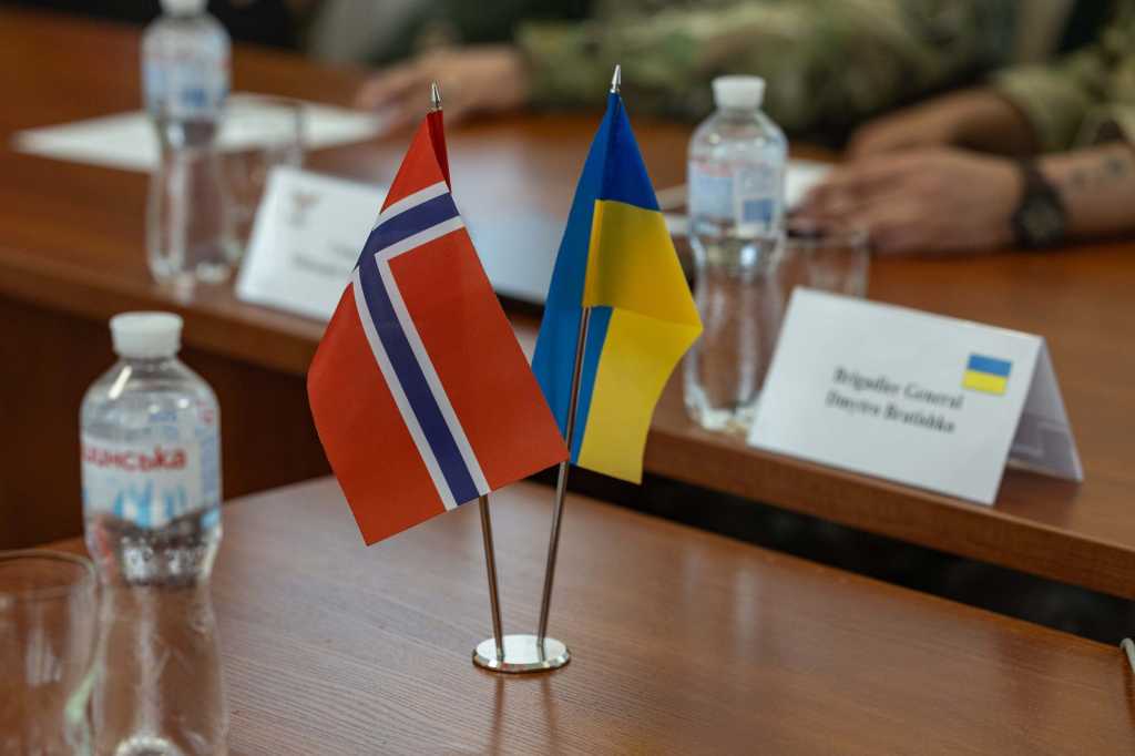 Norsk og ukrainsk flagg på et bord.