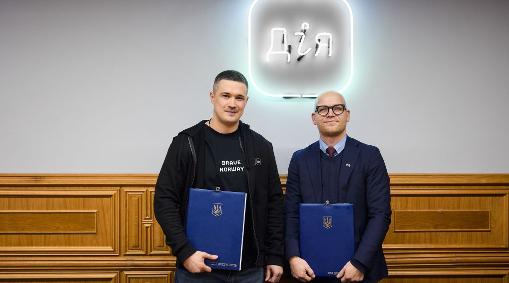 To menn holder hver sin mappe med samarbeidsavtale. Innendørs. 