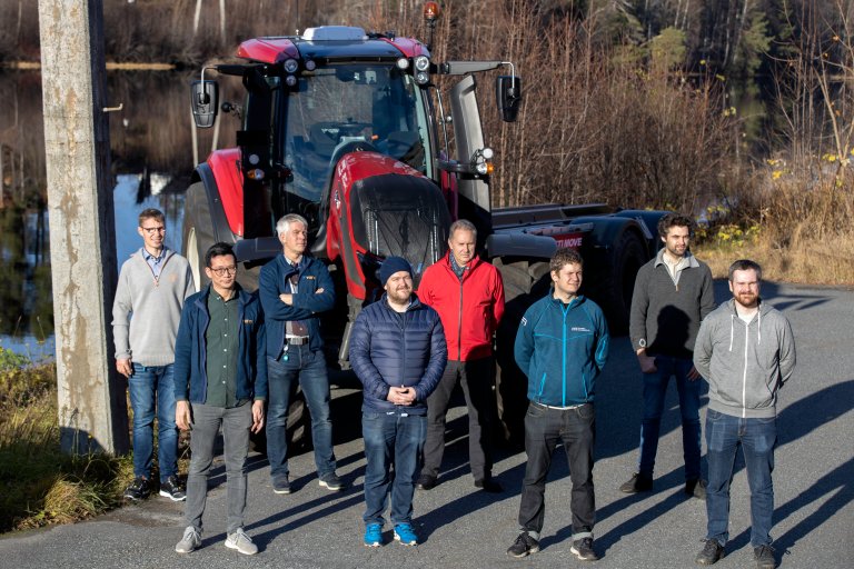 forskere poserer foran en traktor