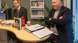 to menn i dress som sitter ved et bord