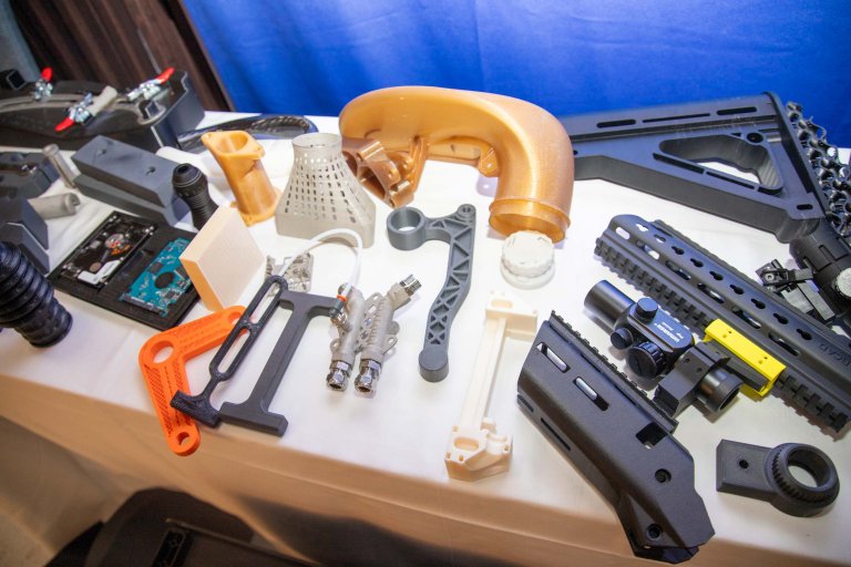 Fleire ulike produkt skrevet ut i 3D utstilt på eit bord.