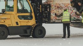 En truck laster av en pall fra lasterampen bak på en C130J-30 Hercules.