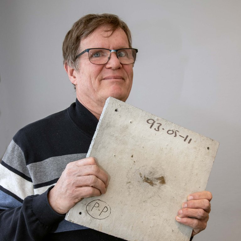 Henrik holder opp en betongplate uten synlige skader.