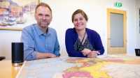 to FFI-forskere sitter bak et bord med et kart over Kina foran seg