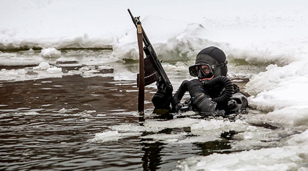 Russisk spesialsoldat i dykkarutstyr i sjøen med is rundt seg på alle kantar.