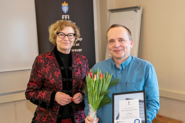 Bukkvoll med blomsterbukett og diplom for årets forskningsformidler sammen med kommunikasjonssjef Anne-Lise Hammer.