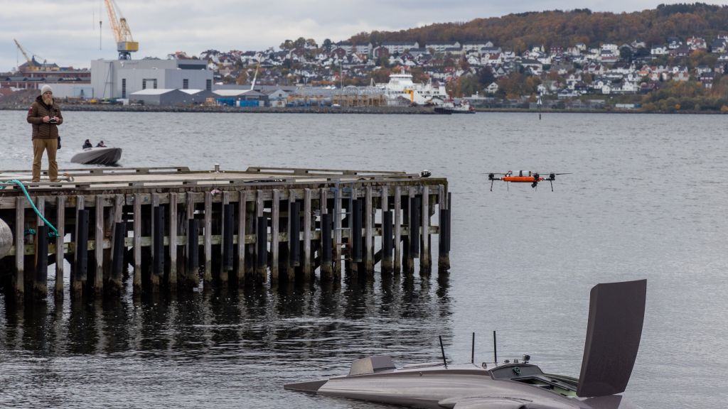 En droneoperatør styrer en drone som flyr ut av et ubemannet fartøy.