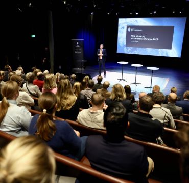 Erik Wold på scenen foran et fullsatt Deichmansal.