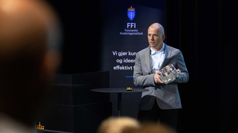 Bendik Sagsveen syner fram ein del i metall som er 3D-printa.