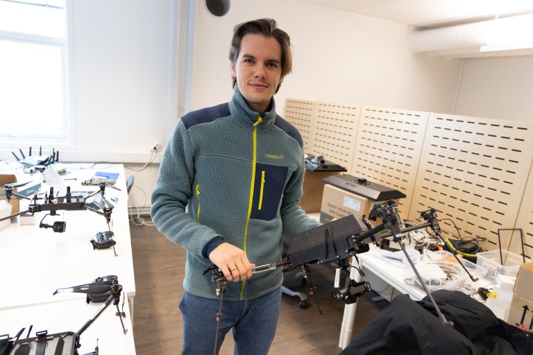 Forsker Mathias Minos-Stensrud holder en drone i verkstedet i Messa på Kjeller.