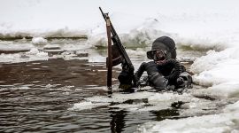 Russisk spesialsoldat i dykkarutstyr i sjøen med is rundt seg på alle kantar.